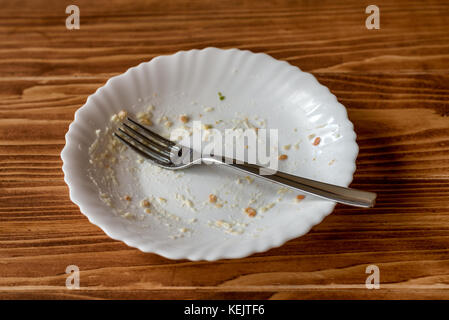 Leeren Teller mit Essen Reste nach dem Essen auf einen hölzernen Tisch Stockfoto