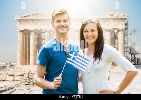 Paar hält die griechische Flagge auf der Akropolis parthenon Tempel Hintergrund Stockfoto