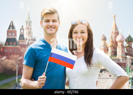 Junge paar hält Russland Flagge vor der hl. Basilius Kathedrale Stockfoto