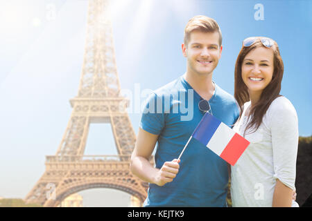 Glückliches Paar französischen Flagge vor Eiffelturm Stockfoto
