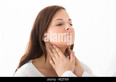 In der Nähe von einem Arzt Hand berühren die Kehle eines weiblichen Patienten in der Klinik Stockfoto