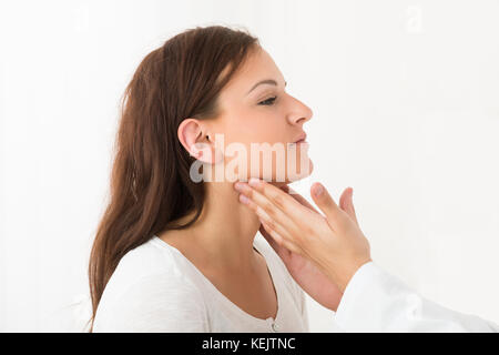 In der Nähe von einem Arzt Hand berühren die Kehle eines weiblichen Patienten in der Klinik Stockfoto