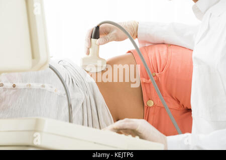 Arzt wird mit Ultraschall Maschine Frauen Bauch in der Klinik Stockfoto