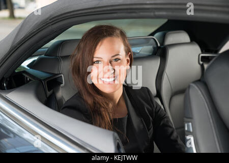Portrait einer jungen Glücklich Geschäftsfrau im Auto sitzen Stockfoto
