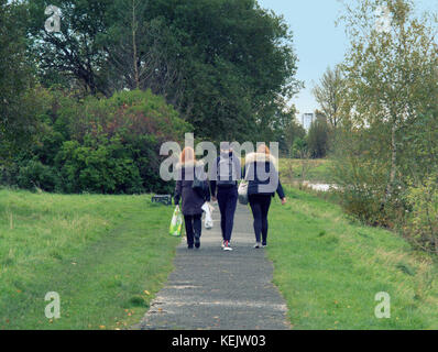 Drei junge Studenten Jungen und Mädchen Rucksäcke wandern aus gesehen hinter der Forth-and-Clyde-Kanal leinpfad Gehweg Pflaster Stockfoto