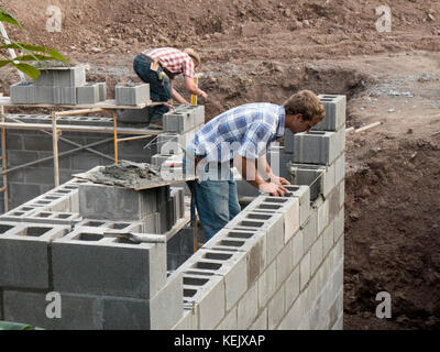 Maurer und Maurerinnen arbeiten am neuen Haus. Stockfoto