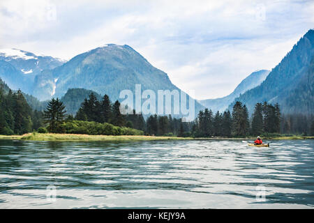 Ein einsamer Kajakfahrer nähert sich der Mündung an der Spitze des entfernten Khutze Inlet, einem Conservancy Gebiet im Great Bear Rainforest an BC es Inside Passage. Stockfoto