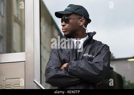 Porträt der jungen afrikanischen männlichen Sicherheit Schutz stehende Arme gekreuzt Stockfoto