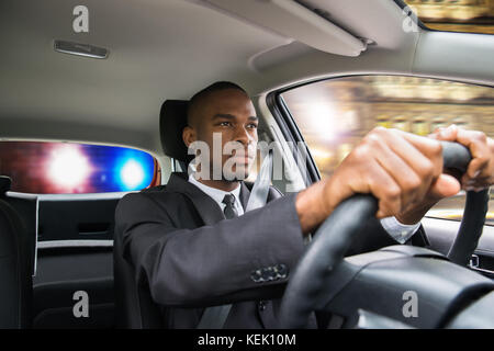 Junge afrikanische Unternehmer gejagt von der Polizei beim Fahren Auto Stockfoto