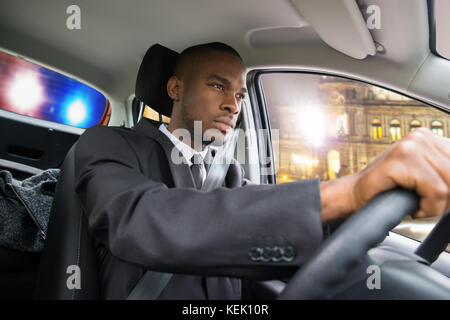 Junge afrikanische Unternehmer gejagt von der Polizei beim Fahren Auto Stockfoto