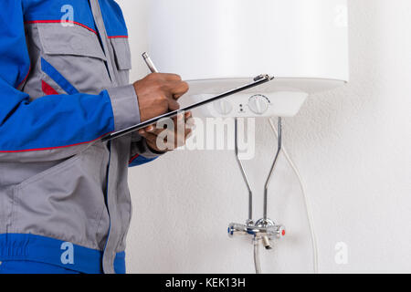 Nahaufnahme der männlichen Klempner schreiben auf Zwischenablage Stockfoto