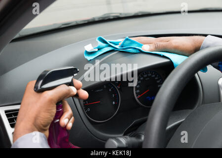 Nahaufnahme eines männlichen Arbeitnehmers Abwischen Armaturenbrett im Auto. Stockfoto