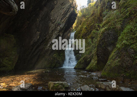 Kleinen versteckten Wasserfall im Wald, in der Felsspalte Stockfoto