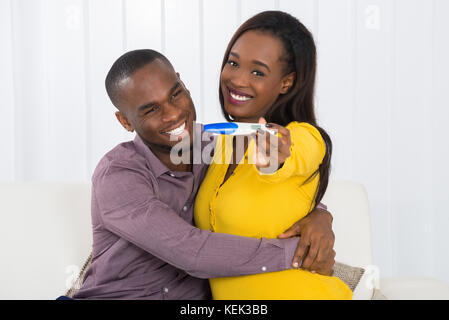 Porträt der jungen afrikanischen glücklich Paar hält Schwangerschaft Test Stockfoto