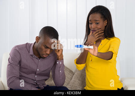 Unglückliche junge afrikanische Paar an der Schwangerschaft Test suchen Stockfoto