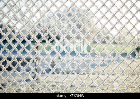 Nahaufnahme von einem Zaun mit Frost Eiskristalle unter einem blauen Himmel mit einem unscharfen Hintergrund an einem sonnigen Wintertag Stockfoto
