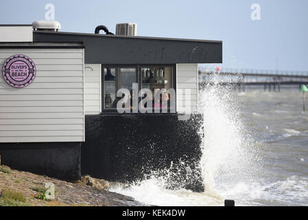 Sturm Brian hit Southend Küste bei Spring Tide verursacht Wellen über den Deichen zum Absturz, und viele Menschen. Kunden weiterhin in Oliver's Restaurant am Strand zu essen Stockfoto