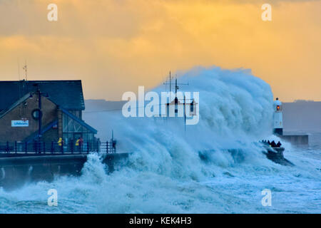 Porthcawl, Wales, Großbritannien. Oktober 2017. Wetter in Großbritannien. Der zweite Sturm der Saison, der von Met Eireann / Met Office benannt wurde, stürmt bei Sonnenaufgang auf die Hafenmauer in Porthcawl und überschwemmt versammelte Zuschauer. Sie droht auch Überschwemmungen in Verbindung mit der hohen Frühlingsflut in West- und Südwales. Die Gemeinderäter waren mit Sandsäcken bereit und die Bewohner halten sich jetzt auf die abendliche Flut. Bildnachweis: IAN HOMER/Alamy Live News Stockfoto