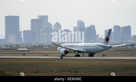 Calgary, Alberta, Kanada. 8. Oktober 2017. Eine Air Canada Boeing 787-9 Dreamliner (c-fghz) wide-Body Jet Airliner landet in Calgary International Airport entfernt. In der Nähe von Calgary Downtown Skyline durch einen rauchigen Dunst durch Waldbrände brennen in British Columbia verursacht gesehen wird. Credit: bayne Stanley/zuma Draht/alamy leben Nachrichten Stockfoto