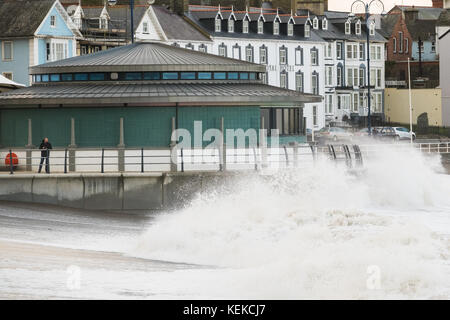 Aberystwyth, Wales, Großbritannien. 22. Oktober 2017. Einen Tag nachdem Aberystwyth eine Schlägerei von Storm Brian genommen hat. Ein Mann schaut zu, wie die Wellen weiter auf dem neuen Strandbandstand der Stadt landen. Quelle: Alan Hale/Alamy Live News Stockfoto