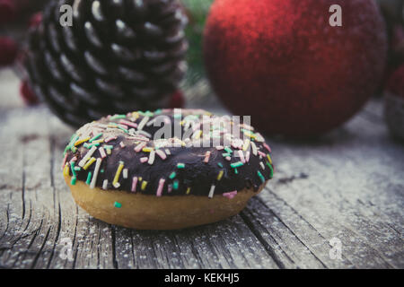 Hausgemachten süßen Krapfen mit Weihnachtsschmuck, auf Holzbrett Stockfoto