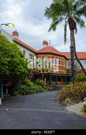 Alte Herrenhaus aus rotem Backstein mit üppigen Garten, Palmen und Auffahrt. Die historischen Schlachthof Erbe Revier Gebäude im Olympic Park, Sydney, Australien Stockfoto