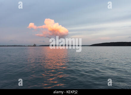 Abendsonne auf Wolken über pembrokeshire Ölraffinerie von einer Yacht an Dale verankert gesehen Stockfoto