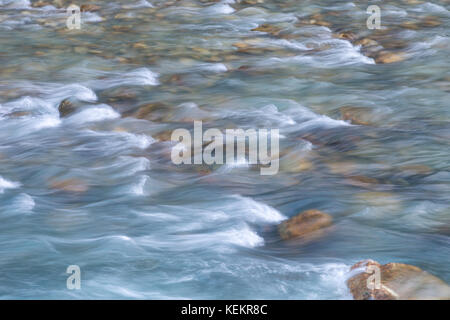 Fließt das Wasser über die Felsen in einem Bach. Stockfoto