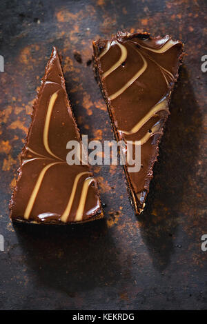 Chocolate Brownie Käsekuchen Schichten. Schokolade und Karamell Käsekuchen mit Brownie Stücke auf schokoladenbiskuit Base. Stockfoto