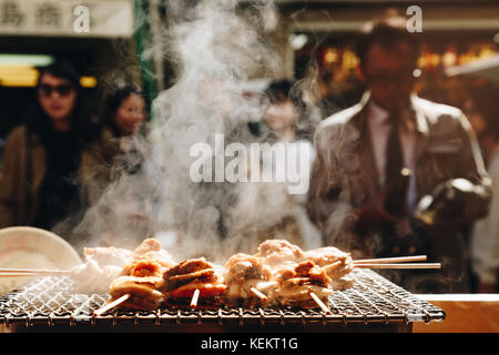 Gegrillten Meeresfrüchten Jakobsmuscheln und Meer ​​urchin Eier Spieß mit Rauch, japanisch Essen in Tsukiji Fischmarkt, Japan. selektive Fokus und Film Stil. Stockfoto