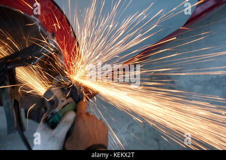 Elektrische rad Schleifen auf Stahl von einem Auto - Auto Body Repair Shop Stockfoto