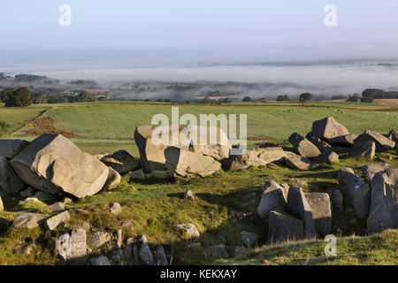 Hadrian's Wall - Kalkstein Ecke: Ausgegrabene Steine am Ufer des nördlichen Grabens mit einem nebligen North Tyne Tal dahinter Stockfoto