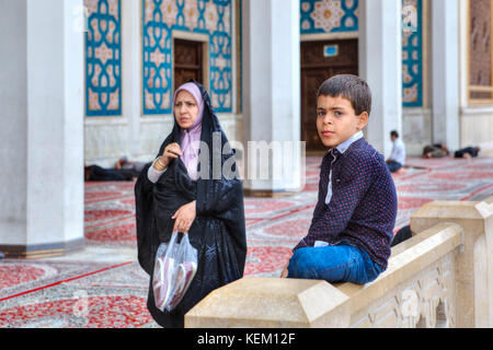 Provinz Fars, Shiraz, Iran - 19. April 2017: Shah Cheragh Heiligtum, muslimische Frau das Tragen eines islamischen Schleier geht von einem der unbekannten jungen, über 10 Ja Stockfoto