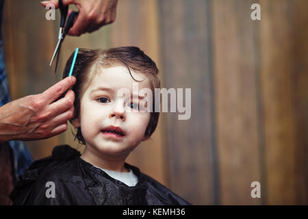 Ein kleiner Junge ist in der Friseur getrimmt Stockfoto