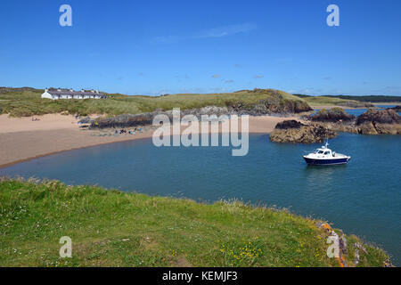 Kleines Boot im Meer vor Llanddwyn Island, Anglesey, Wales, Großbritannien Stockfoto