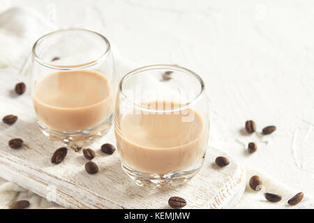 Irish Cream Kaffee Likör und Kaffeebohnen über weiß Holz- Hintergrund - Hausgemachte festliche alkoholisches Getränk Stockfoto