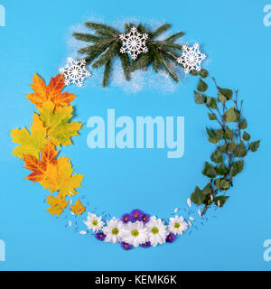 Kranz aus natürlichem Material, symbolisiert die Jahreszeiten, auf blauem Hintergrund. top View Stockfoto