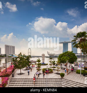 Touristen in der Nähe der Merlion und mit Blick auf einige der wichtigsten Sehenswürdigkeiten von Singapur - die Marina Bay Sands, der Kunst und Wissenschaft Museum Stockfoto