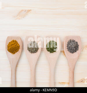 Essen kochen Zutaten. getrocknete Gewürze Currypulver, schwarzer Pfeffer, Pulver, Oregano und Thymian in hölzernen Löffel auf rustikalen Holzmöbeln Hintergrund. Stockfoto