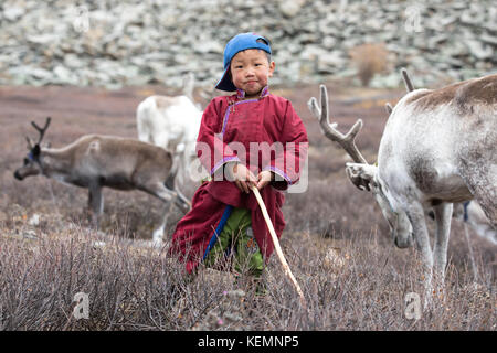 Wenig tsaatan Junge in traditionellen mongolischen Nomaden Outfit mit Rentier seiner Familie posieren. khuvsgol, Mongolei. Stockfoto