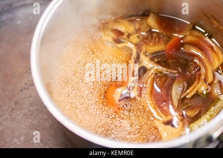 Geschmack Schaft von Lamm kochen im Topf langsam gekochte Lammkeule mit Brühe in Kasserolle hautnah. Leckeres Essen der europäischen Restaurant. Stockfoto