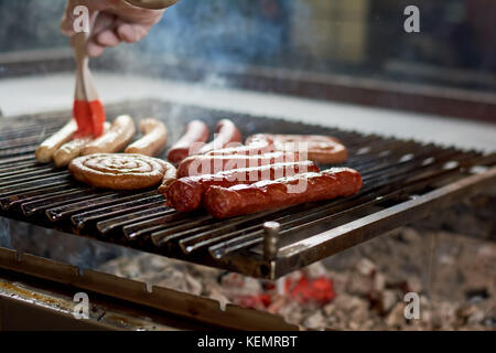 Bbq mit Würstchen auf den Grill. Küchenchef verschiedene Würstchen auf einem Grill. verschiedene köstliche Fleisch. Stockfoto