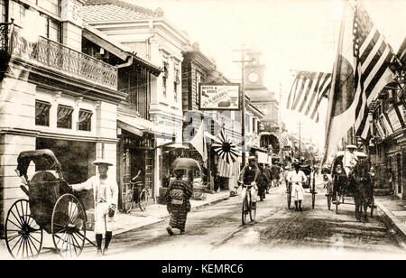 Japan, Yokohama. Jahrgang, ca. 1900, schwarze und weiße Postkarte von belebten Straße Szene in der japanischen Stadt. Benten-cho-dori, us-amerikanischen und japanischen Flaggen. Stockfoto