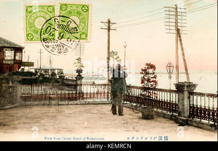 Japan, Yokohama. Jahrgang, ca. 1900, handkoloriert Postkarte von Mann mit Teleskop im Grand Hotel. Briefmarken und Poststempel auf. Stockfoto