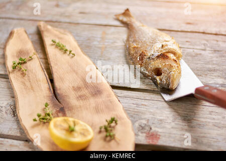 Gegrillte dorado Fisch mit Gewürzen auf Holztisch. gegrillter Fisch, Forelle Fisch auf Holz- Hintergrund schliessen. Stockfoto