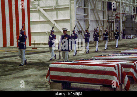 Dover, Delaware. Usa, 29 Oktober, 1983 um genau 7 Uhr, ein marine Ehrengarde und Color Guard in den zeremoniellen Dress Uniform in einem riesigen Hangar an der Dover Air Force Base marschierten und Stand 16 Särge. hinter Ihnen, unterbrochen von den Strahlen der Hangar, war ein 38-Fuß-amerikanische Flagge. Die Zeremonie der Erste auf amerikanischem Boden zu Ehren der Soldaten in den Bombenanschlag in Beirut und die Invasion von Grenada getötet wurde. Stockfoto