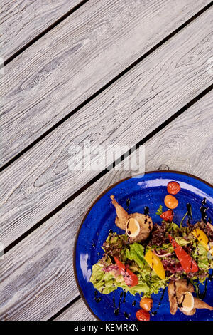 Warmer Salat mit Wachtel Fleisch und grünem Salat. appetitliche Salat auf Tisch im Restaurant und kopieren Sie Raum, Ansicht von oben. Stockfoto