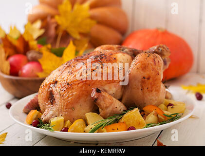 Gebratener Truthahn mit Preiselbeeren garniert auf einem rustikalen Stil Tabelle mit Kürbissen, Orangen, Äpfel und Herbst Blatt eingerichtet. Tag Thanksgiving. Stockfoto