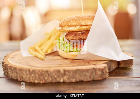 Big Burger mit Rindfleisch. hohe Burger mit Fleisch und frisches Gemüse aus natürlichem Holz. Stockfoto