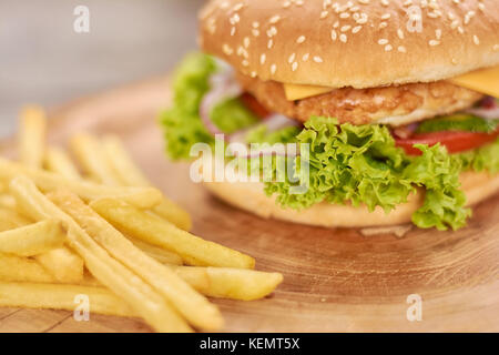 Klassische amerikanische Burger essen. leckere Burger mit hühnerschnitzel und frischem Gemüse. Cheeseburger mit Pommes frites. Stockfoto